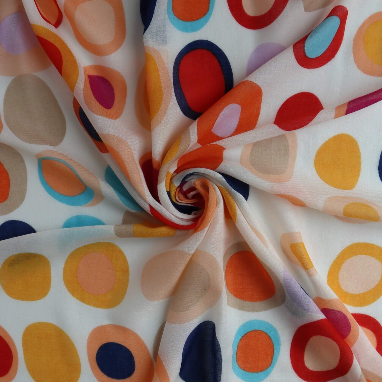 Creamy white scarf fabric with a groovy retro circle design in navy, orange, pink, light blue, and red. Light, flowing textile with a central spiral.