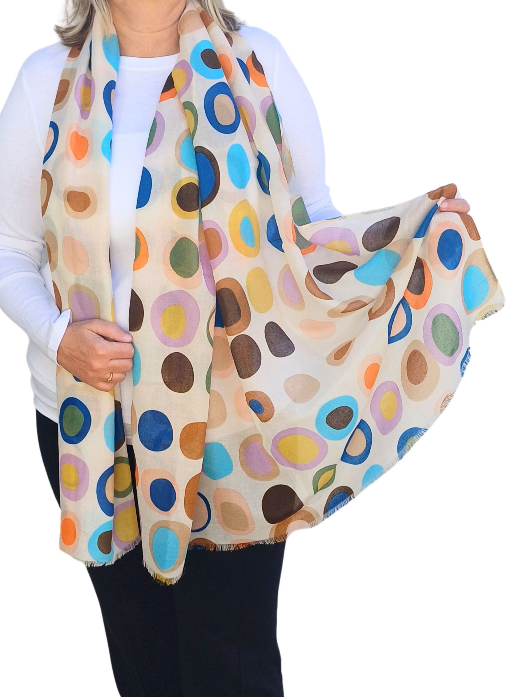 Beige scarf with a retro-style oval and circle pattern in brown, blue, green, orange, and lilac. Soft, flowing fabric with a delicate fringe.