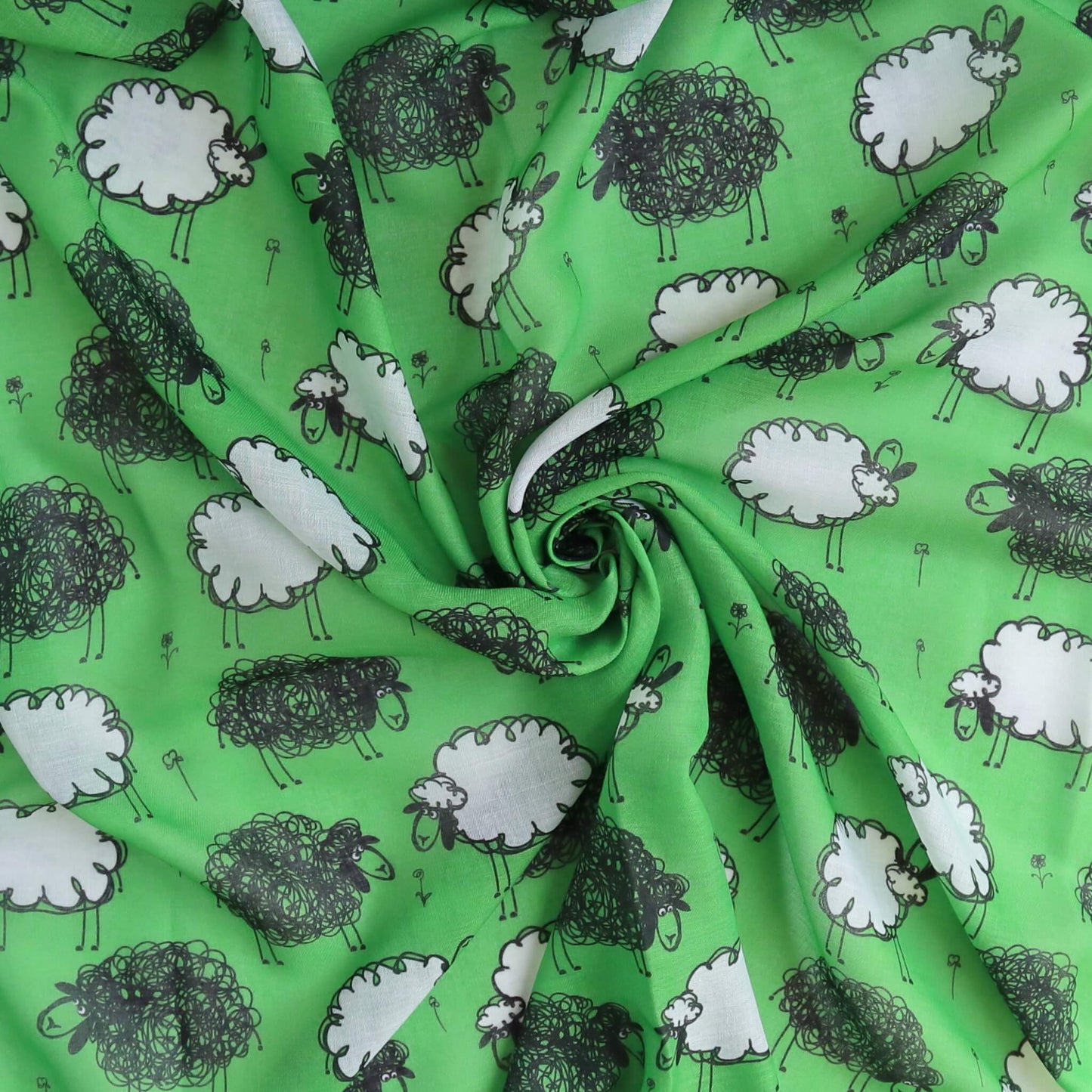 Bright green scarf fabric with a playful pattern of black and white sheep. Soft, flowing texture with gentle folds.