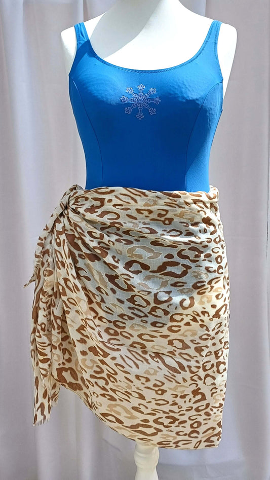 Leopard print beach wrap in shades of brown, tan, and cream, tied at the hip. Lightweight, semi-sheer fabric with a flowing drape.