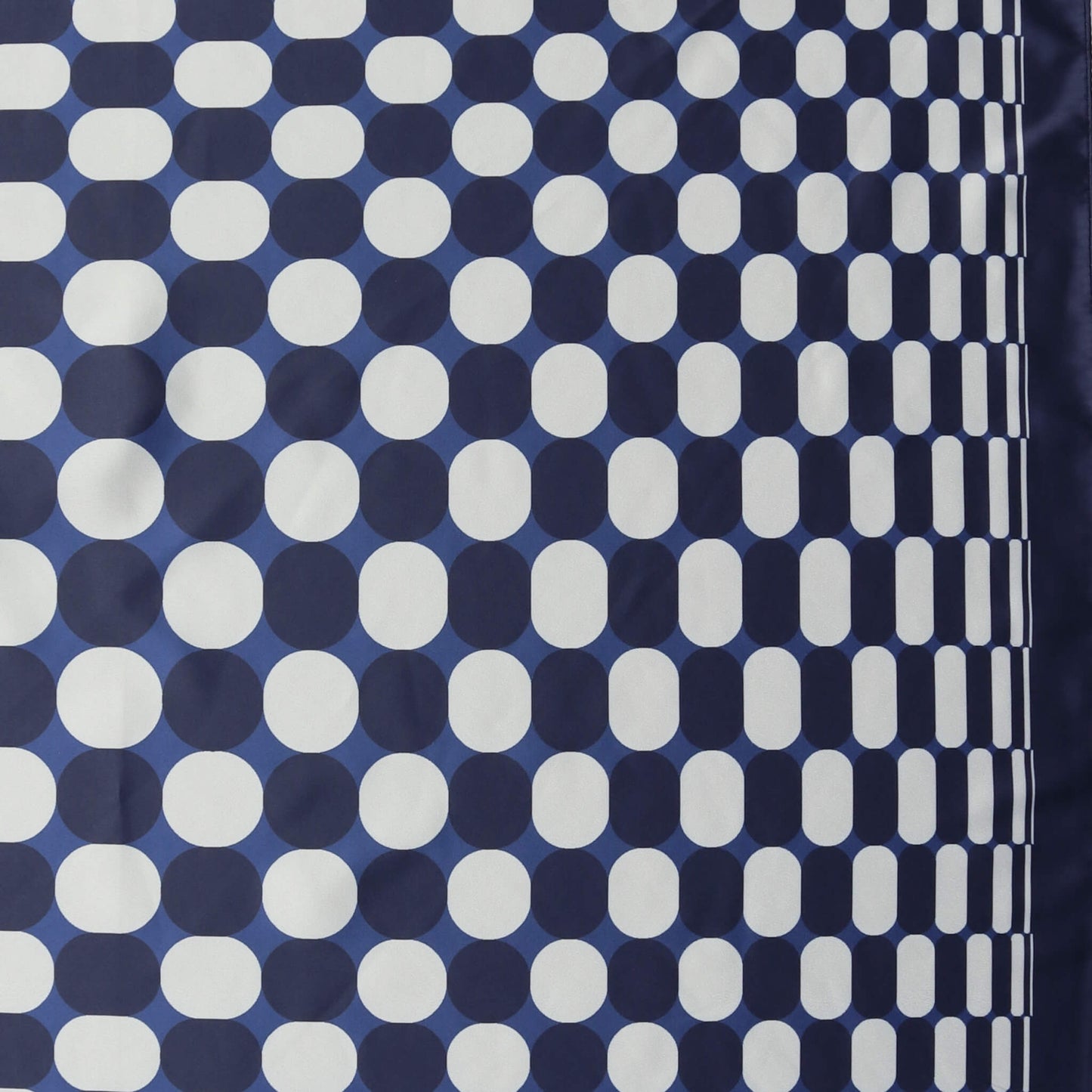 Aurora's Array: Close-up of a small square satin scarf with a geometric pattern of white dots on a navy blue background, featuring a border design of clustered white dots on the right edge.