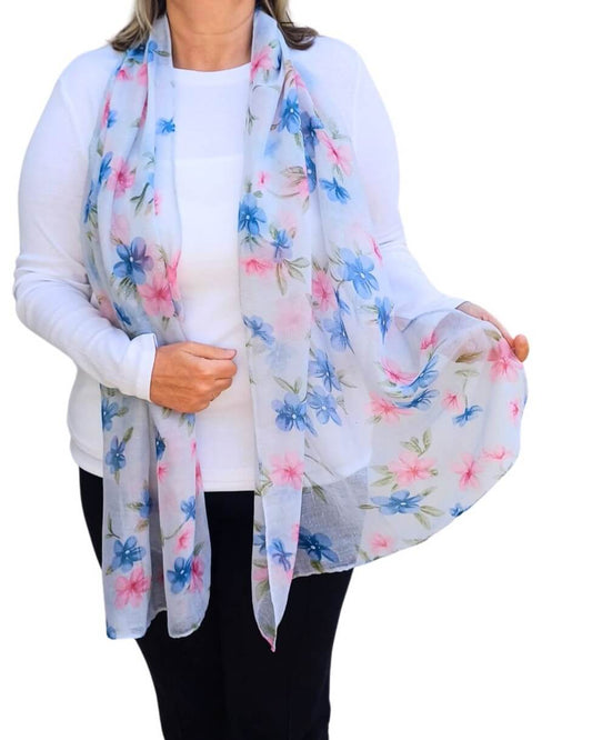 Aurora's Array: Woman models a soft, lightweight light blue scarf with a pink and blue floral print.
