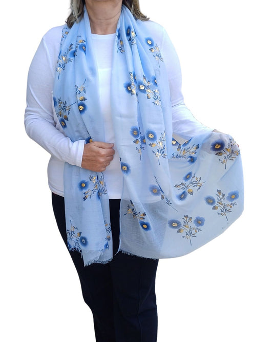 Aurora's Array: Woman models a soft, lightweight light blue scarf with a small blue and gold floral print.
