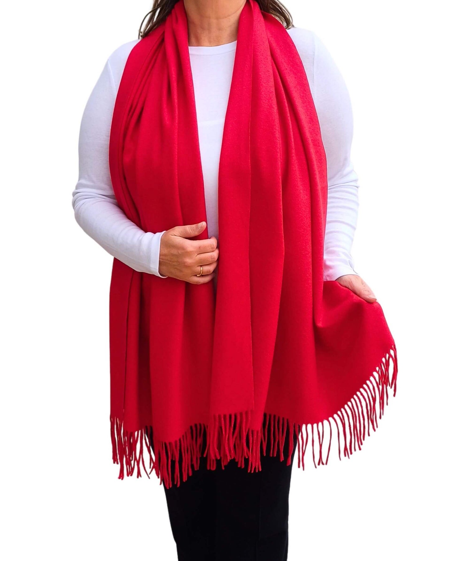 Aurora's Array: Woman models a soft, warm bright red wool blend scarf with fringed edges, draped around her neck and shoulders.