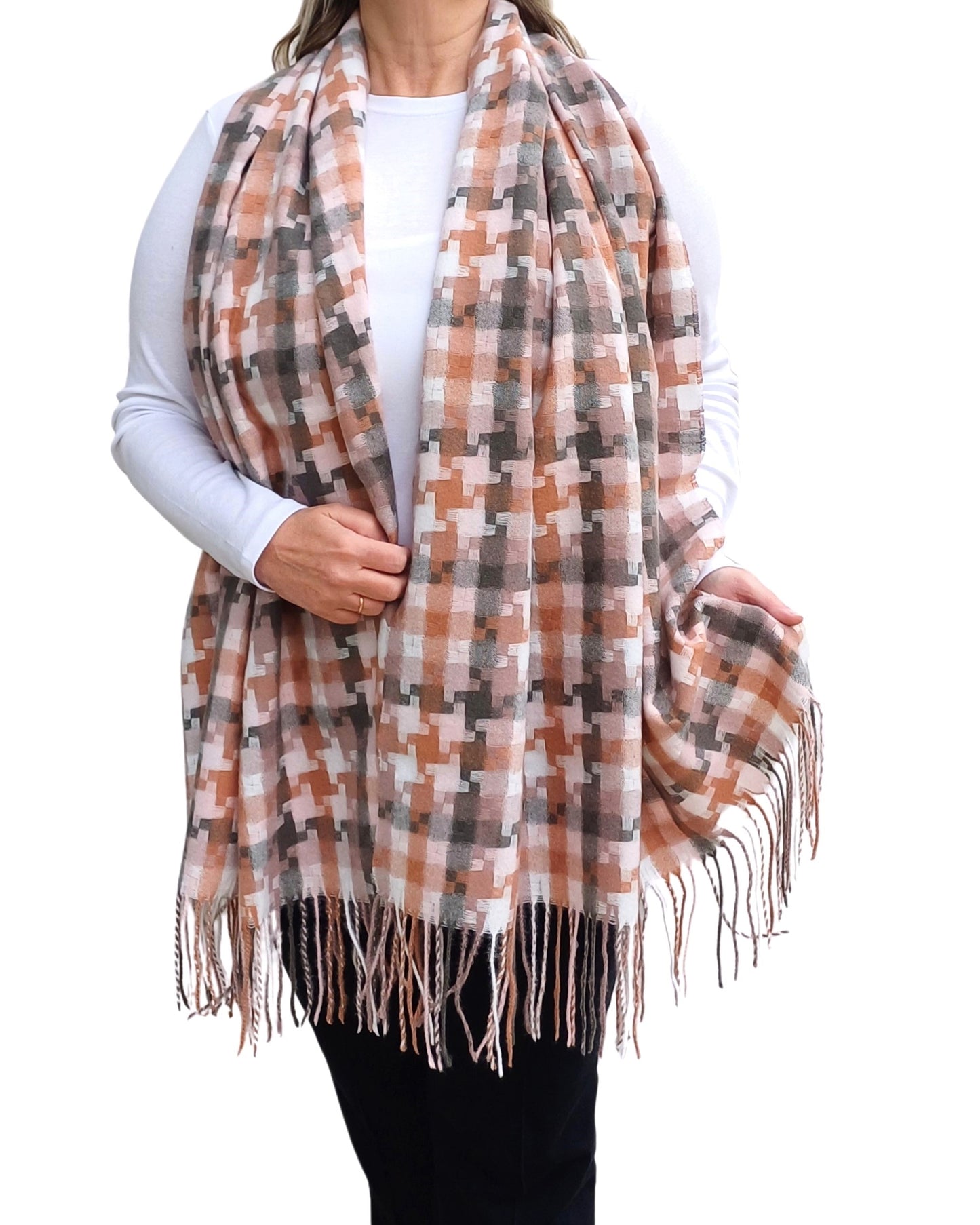 Aurora's Array: Woman models a soft, oversized plaid scarf in shades of peach, brown, grey, and cream with fringed edges.