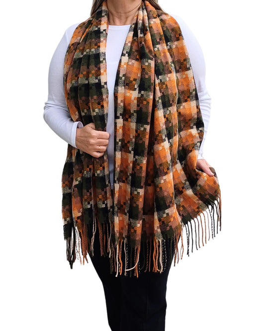 Aurora's Array: Woman models a warm, oversized plaid scarf in shades of orange, brown, green, and cream with fringed edges.