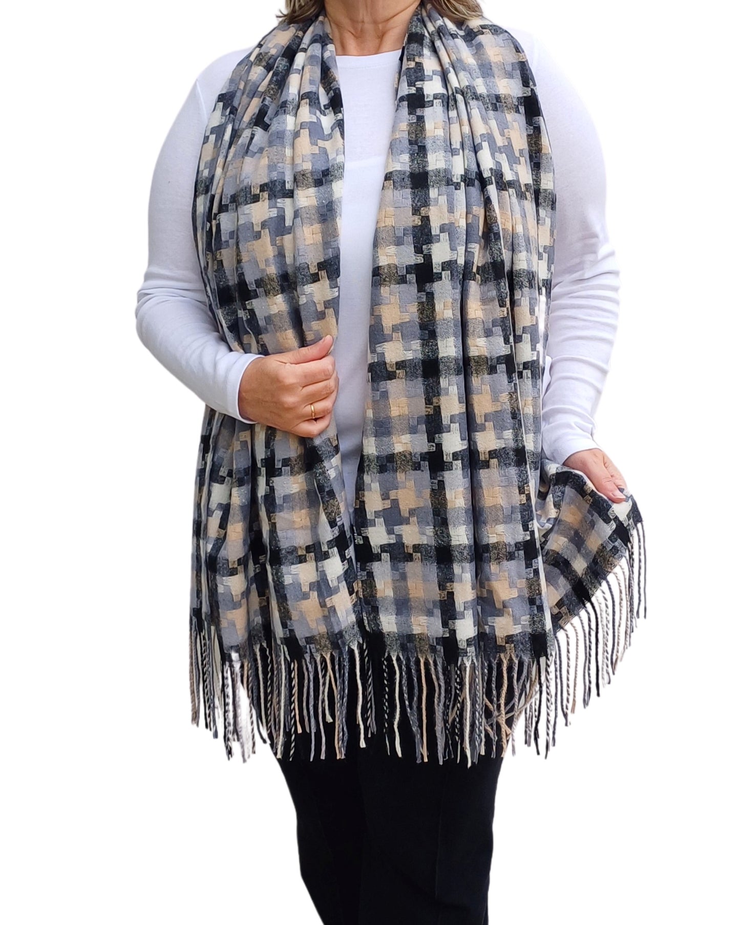 Aurora's Array: Woman models a soft, oversized plaid scarf in shades of black, grey, cream, and a hint of peach with fringed edges.