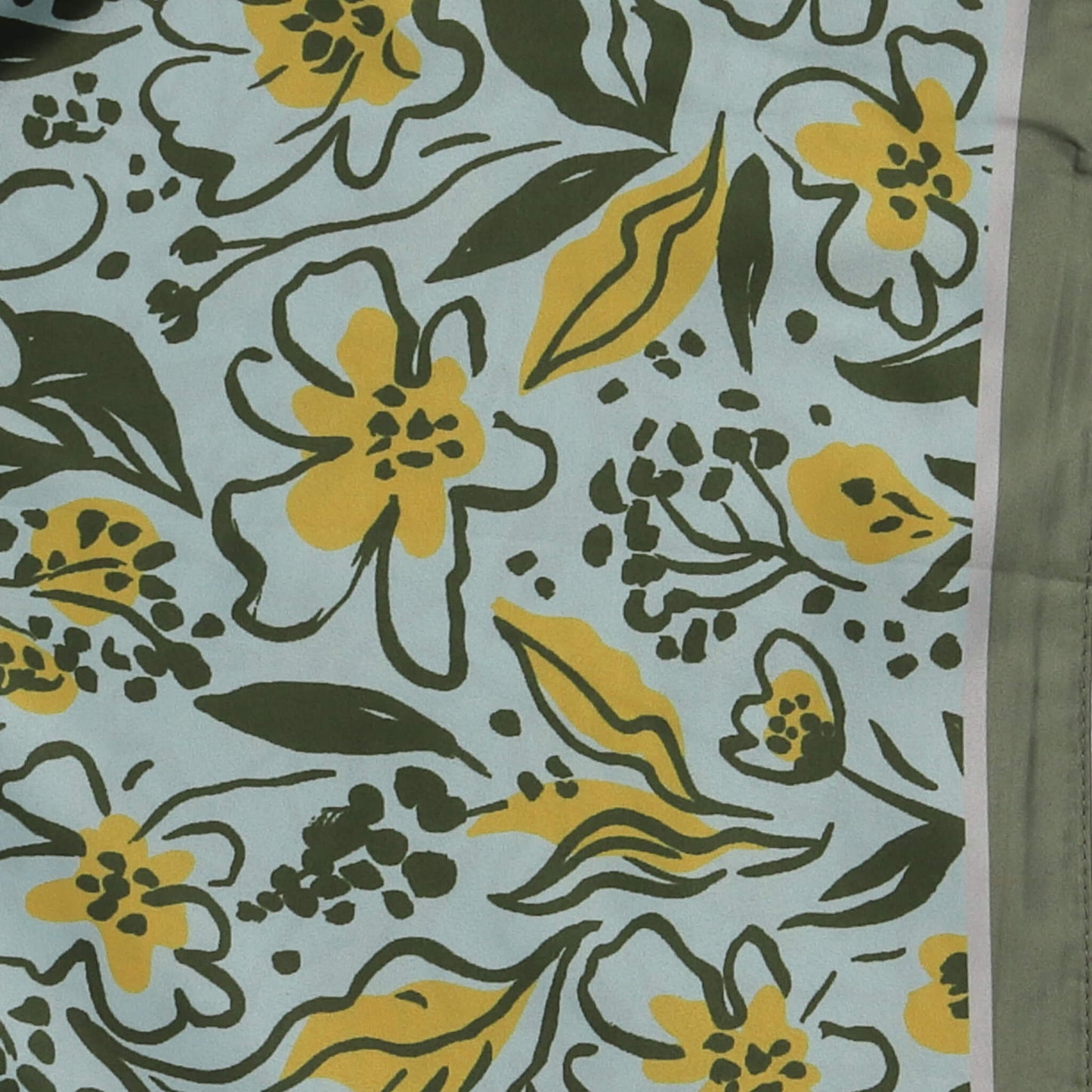 Aurora's Array: Close-up of a small square silk scarf with a floral pattern in shades of green and yellow on a light blue background.