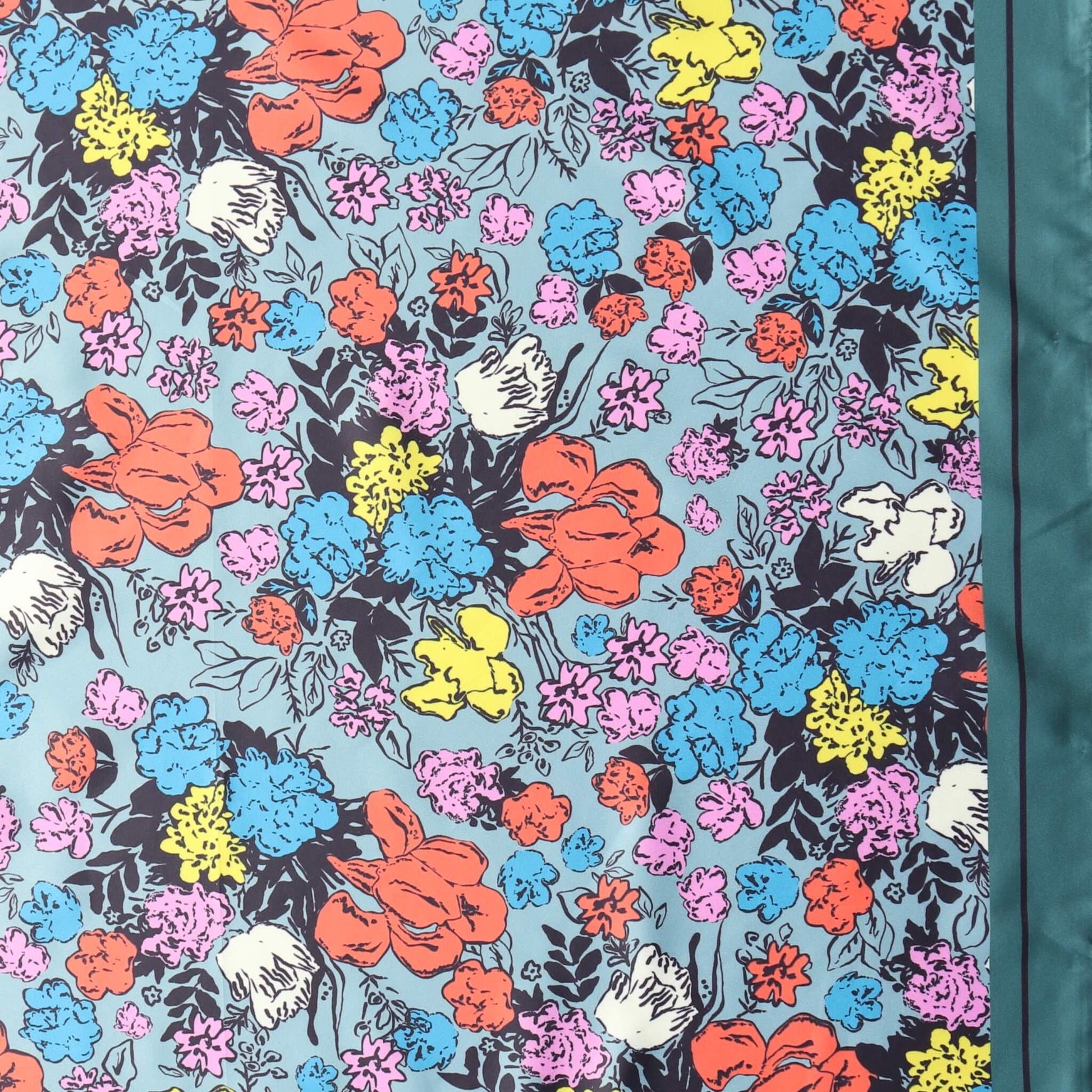 Aurora's Array: Close-up of a small square satin scarf with a vibrant floral print in shades of pink, yellow, blue, orange, and white on a light blue background, featuring a dark teal border on the right edge.