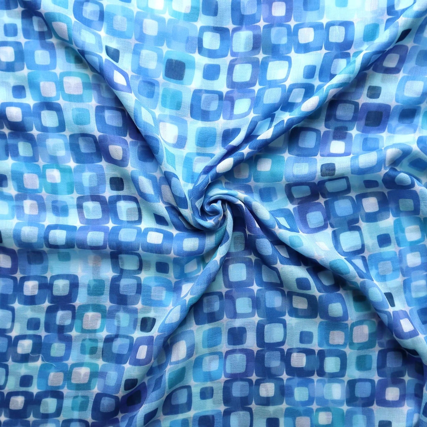 Lightweight scarf fabric with a bright geometric square pattern in various shades of blue and white. Soft summer textile.
