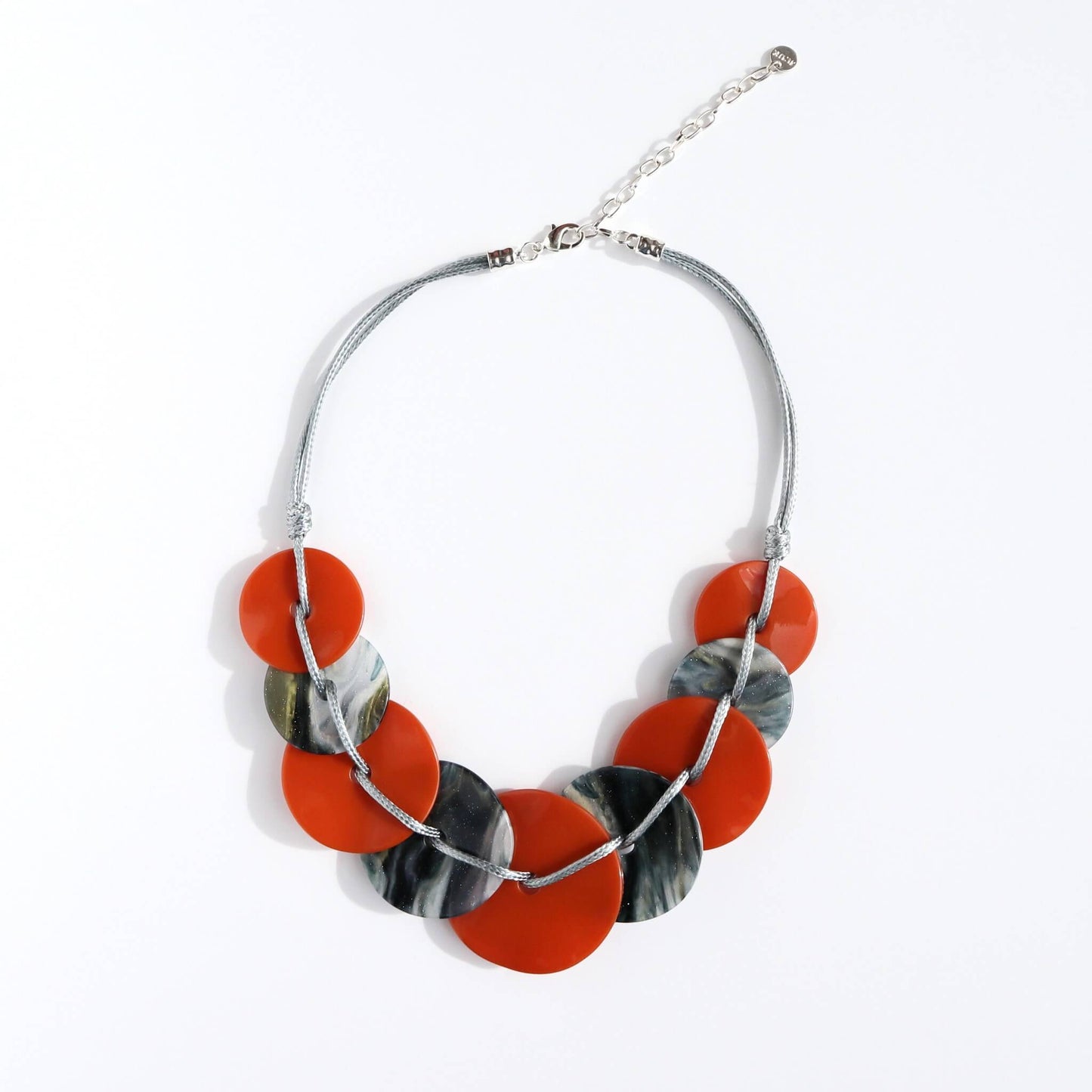 Lightweight statement necklace featuring alternating orange and grey marbled flat circular beads. Connected by silver-toned wire with an adjustable clasp.