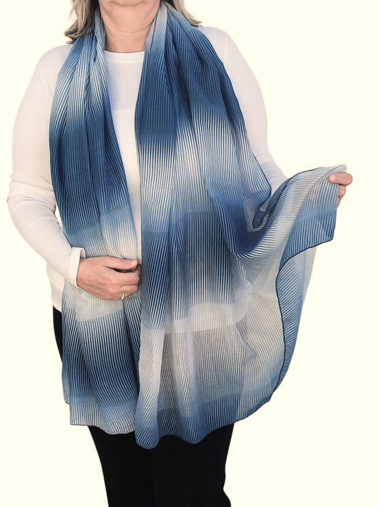 Ombre scarf with flowing, textured stripes in shades of grey and blue. Lightweight fabric with a soft drape.