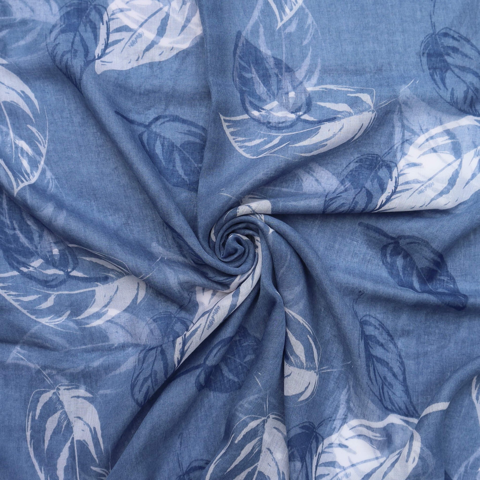 Aurora's Array: Close-up of a soft, lightweight blue scarf with a large white leaf print, swirled to show detail.