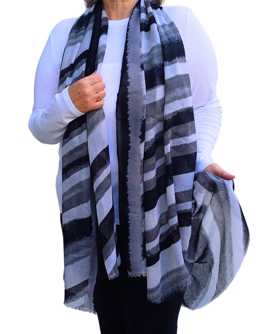 Aurora's Array: Woman models a soft, lightweight oversized scarf with diagonal stripes in black, grey, and white.