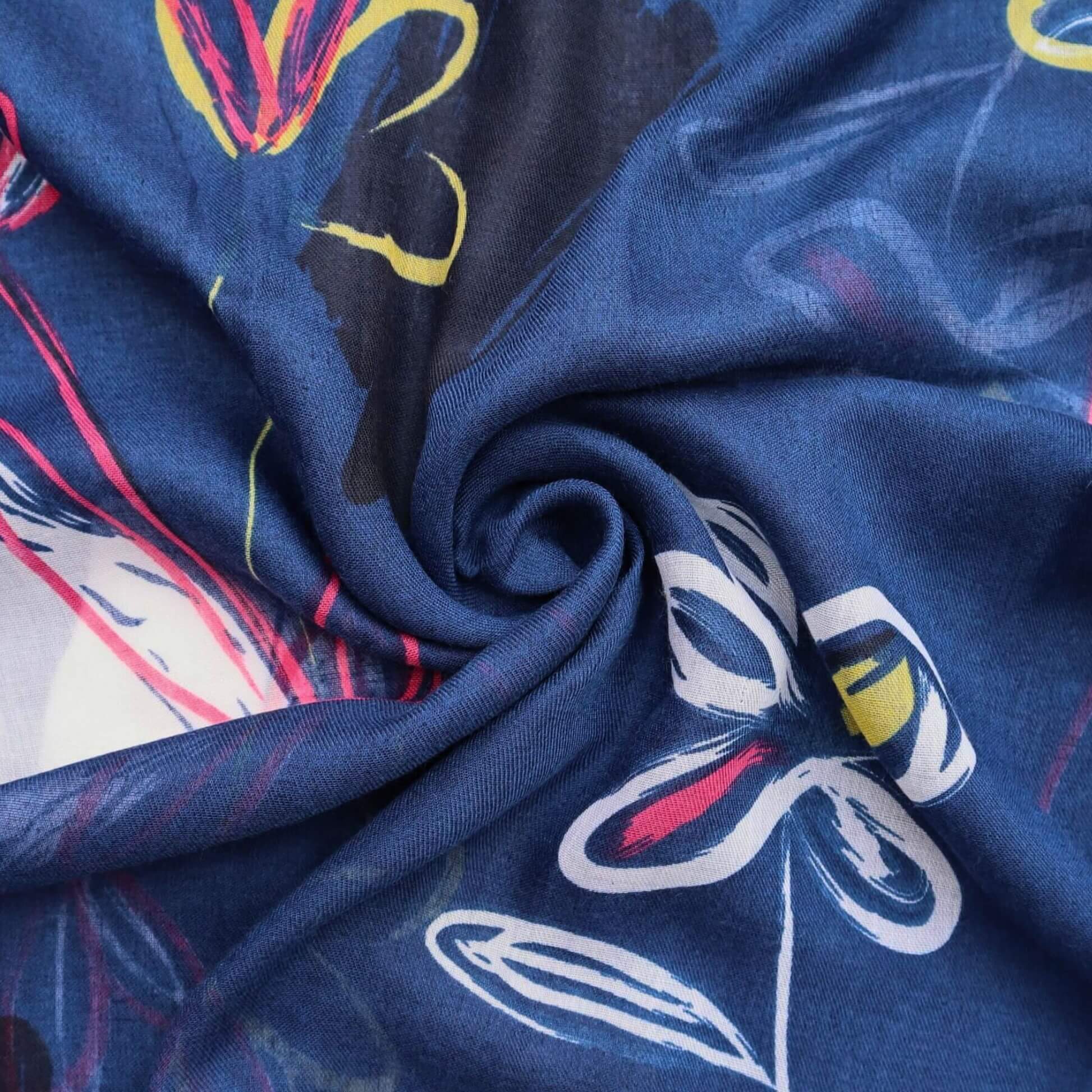 Aurora's Array: Close-up of a soft, lightweight scarf with an abstract floral sketch print in shades of navy blue, white, pink, and yellow, swirled to show detail.