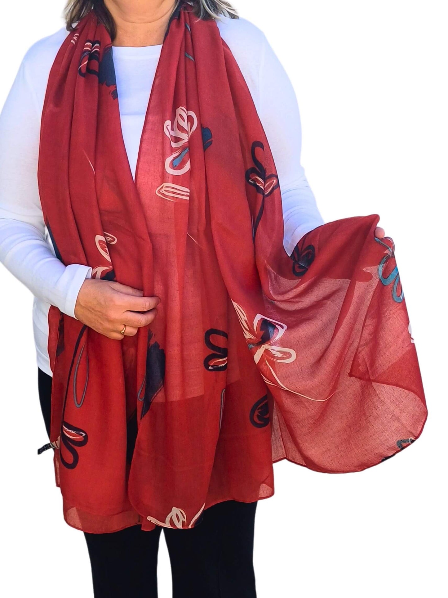 Aurora's Array: Woman models a soft, lightweight oversized scarf with an abstract floral print in shades of red, white, and blue.