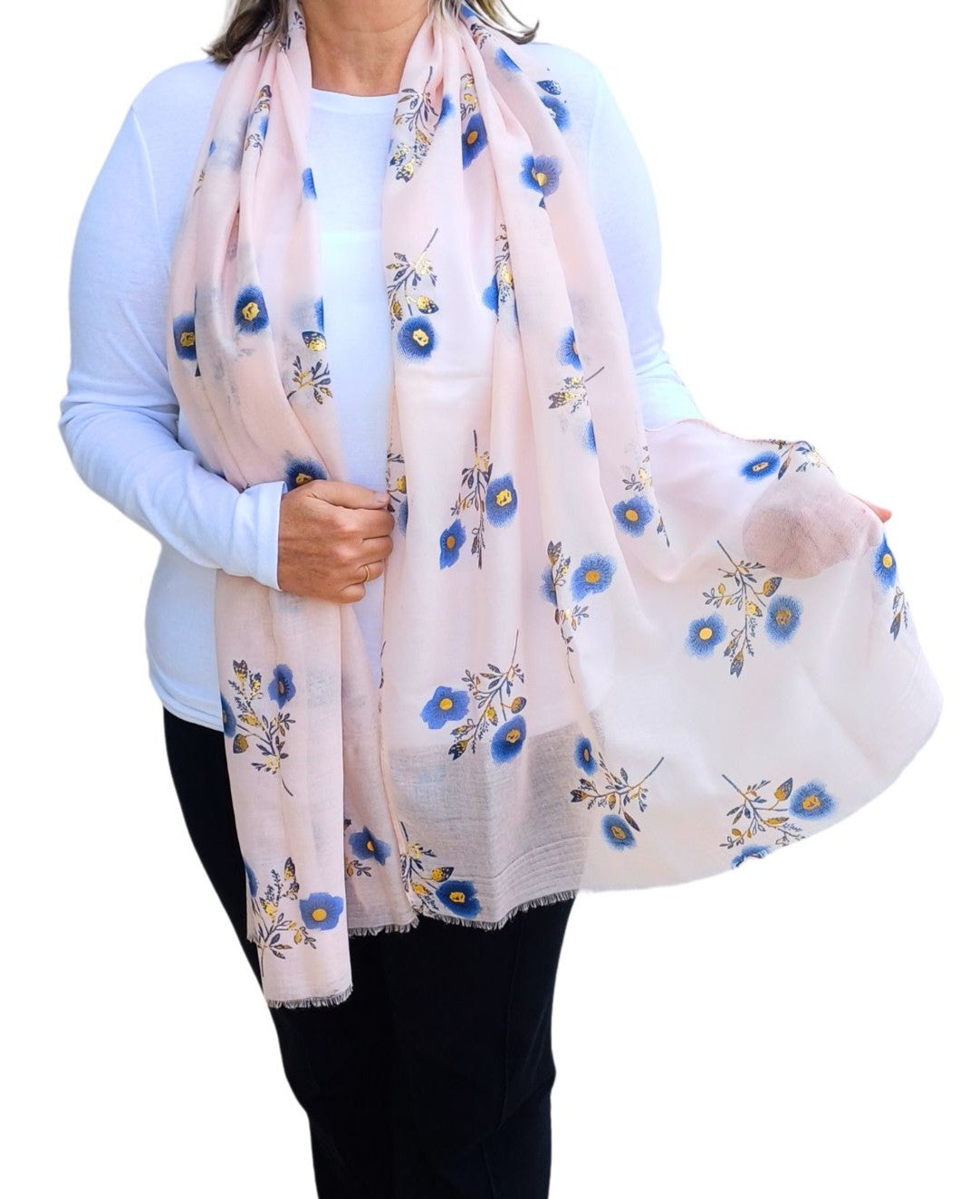 Aurora's Array: Woman models a soft, lightweight pale pink scarf with a small blue and gold floral print.