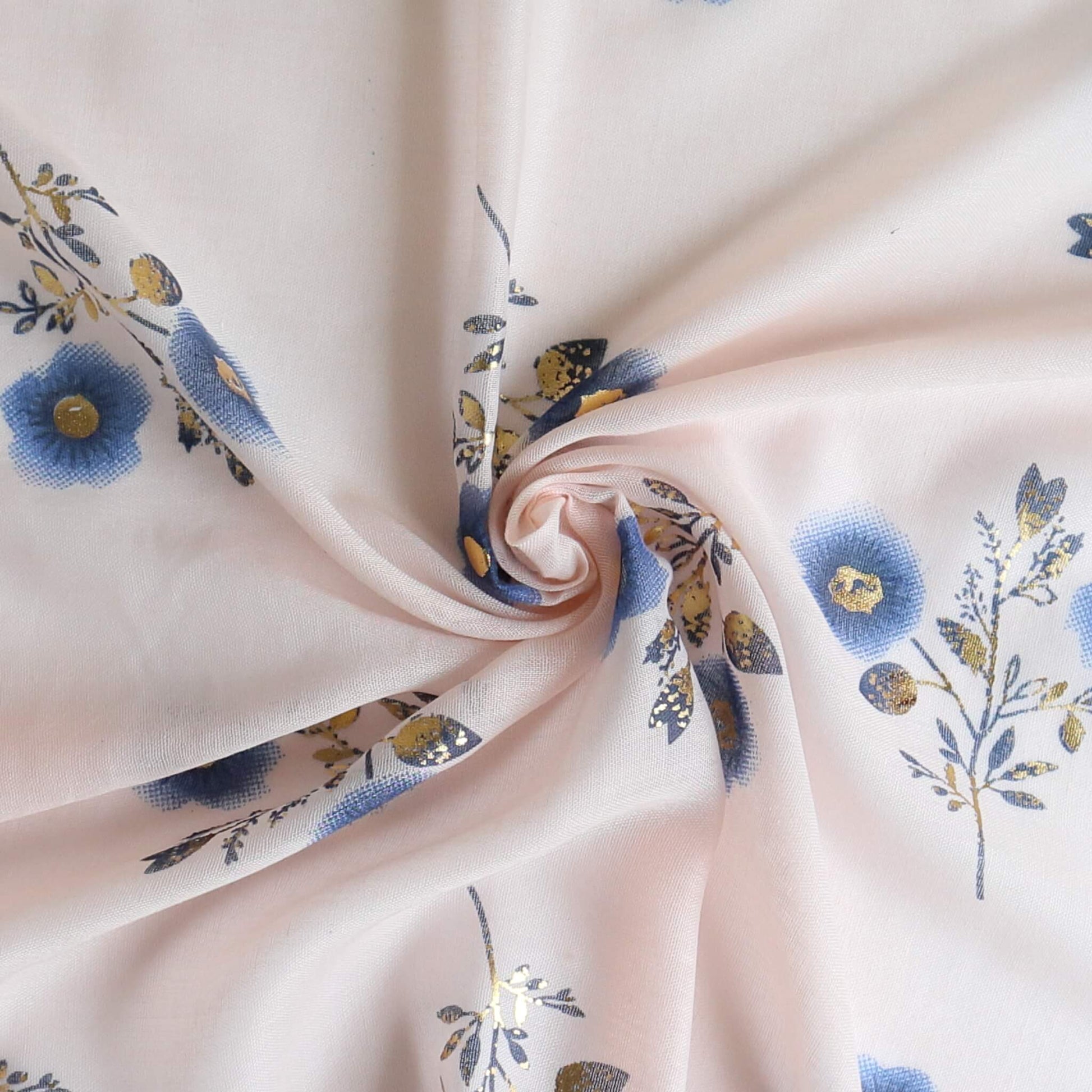 Aurora's Array: Close-up of a soft, lightweight pale pink scarf with a small blue and gold floral print, swirled to show detail.