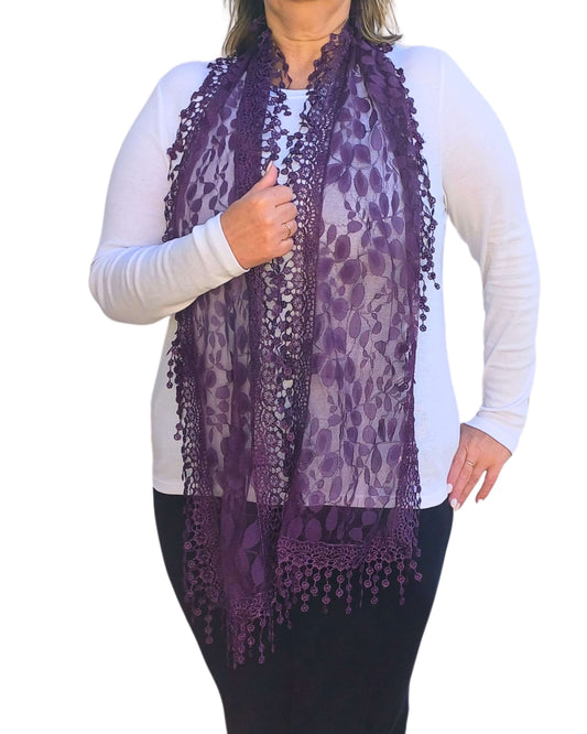 Aurora's Array: Woman models a rich purple lace scarf with a delicate leaf pattern and fringed edges.