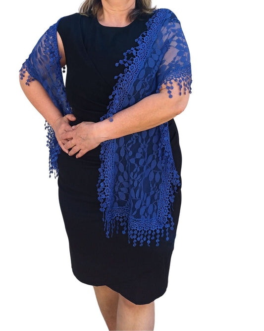 Aurora's Array: Woman models a rich royal blue lace scarf with a delicate leaf pattern and fringed edges.