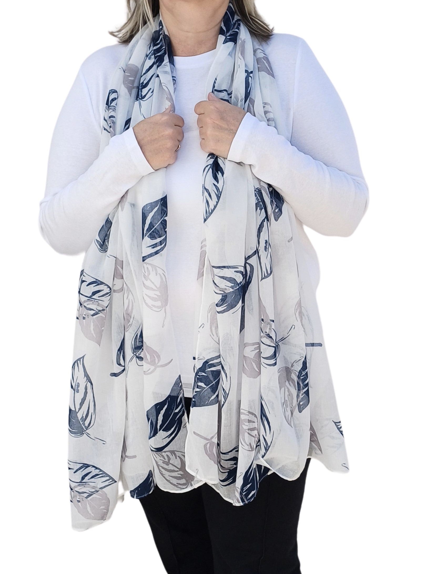 Aurora's Array: Woman models a soft, lightweight oversized white scarf with a large leaf print in shades of grey and navy blue.