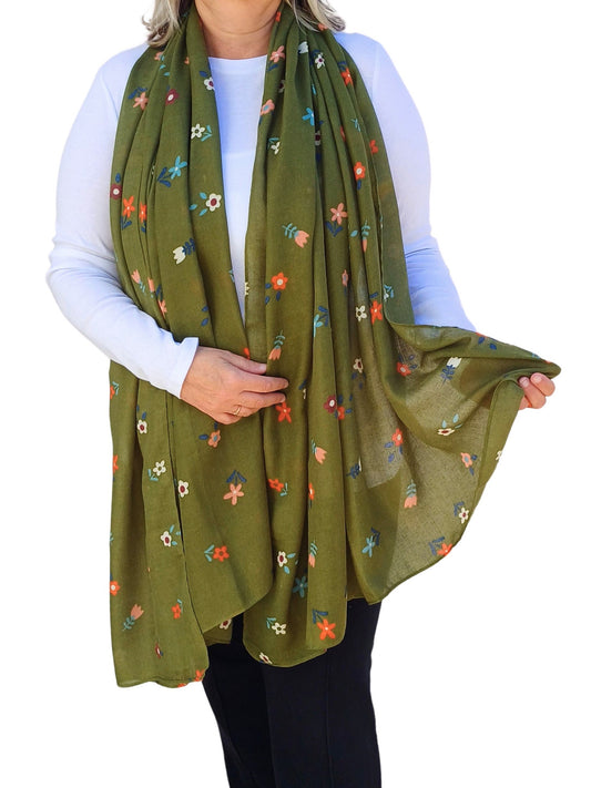Aurora's Array: Woman models a soft, olive green scarf with a delicate floral print in various pastel colours.