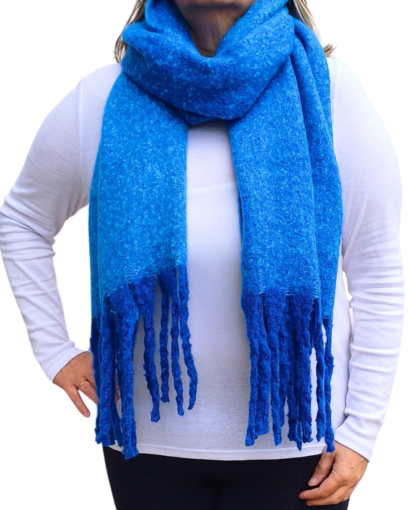 Aurora's Array: Woman models a soft, textured bright blue knit scarf with long fringe.