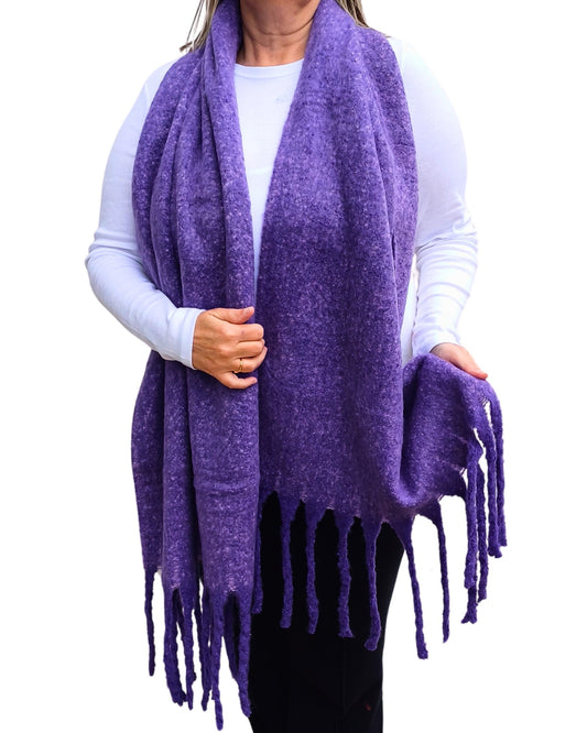Aurora's Array: Woman models a soft, textured bright purple knit scarf with long fringe.