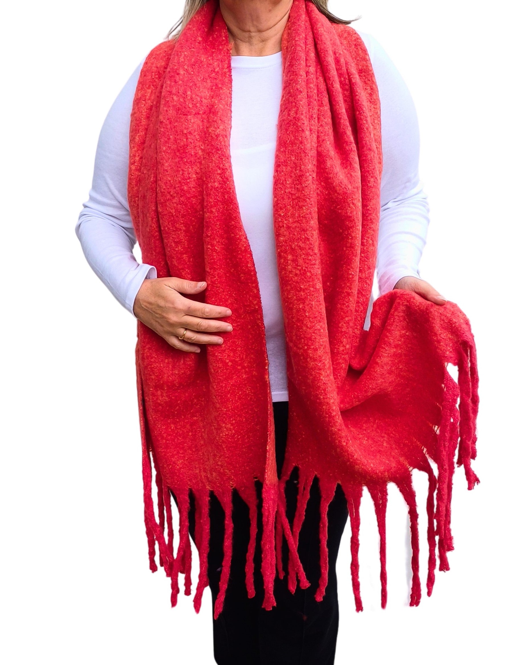 Aurora's Array: Woman models a soft, textured bright red knit scarf with long fringe.