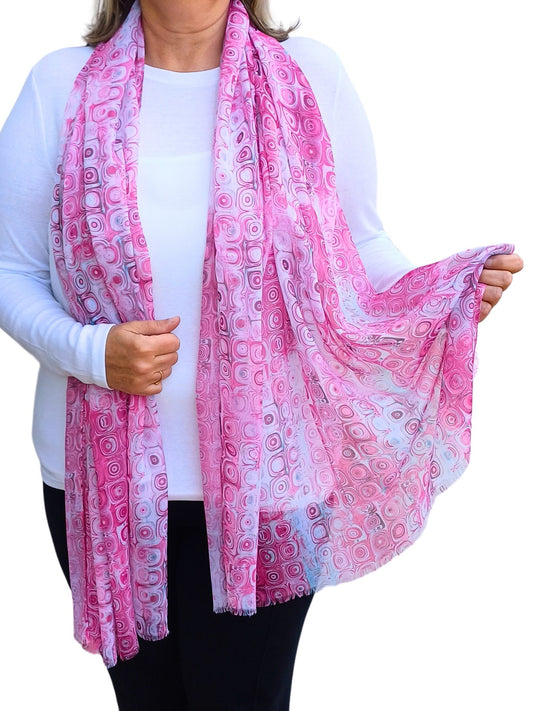 Vibrant pink scarf with a retro geometric circle design in varying pink and white tones. Lightweight and stylish fashion accessory.