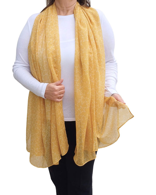 Aurora's Array: Woman models a soft, lightweight yellow scarf with a subtle white star print.