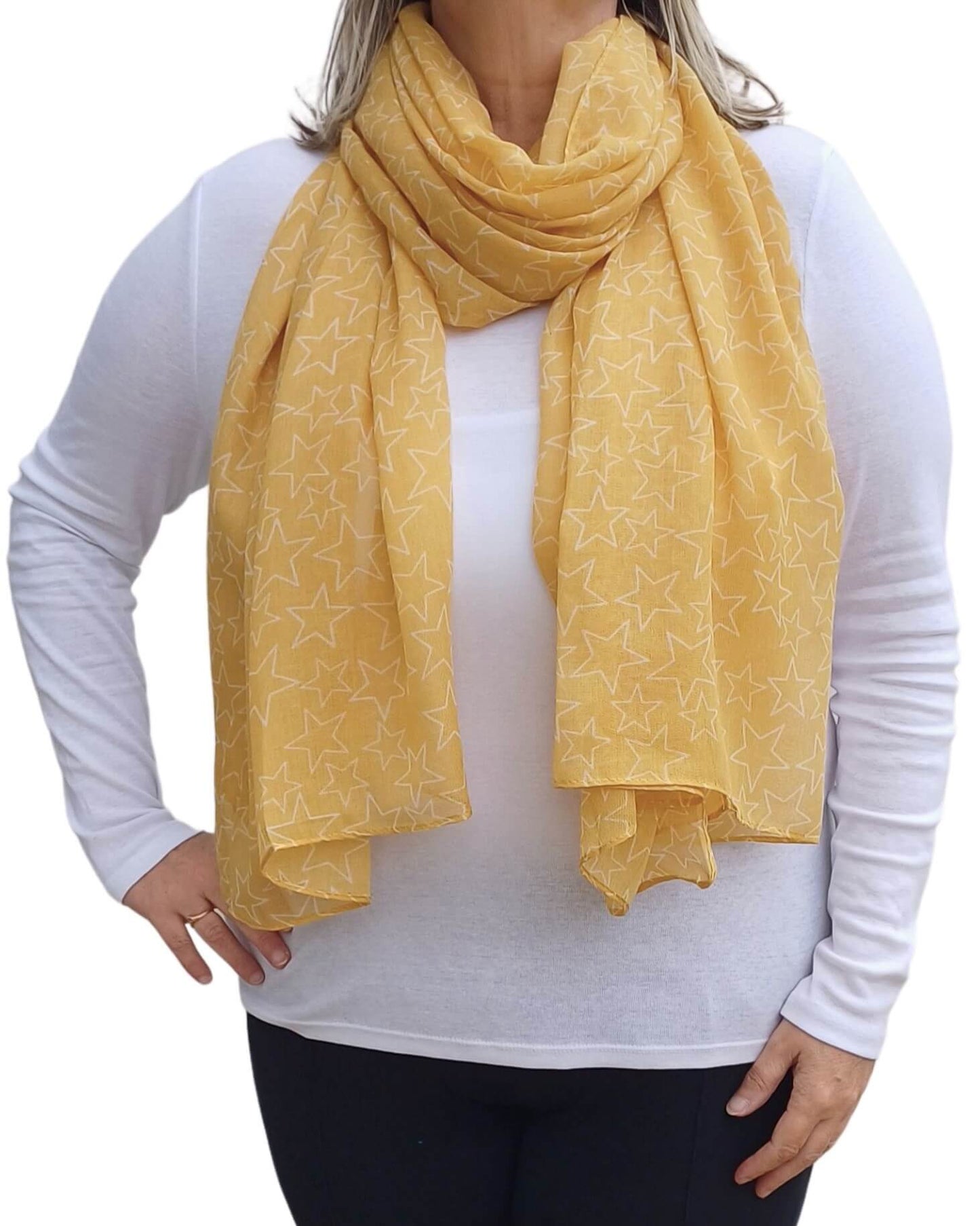 Aurora's Array: Woman models a soft, lightweight mustard yellow scarf with a subtle white star print, wrapped around her neck.