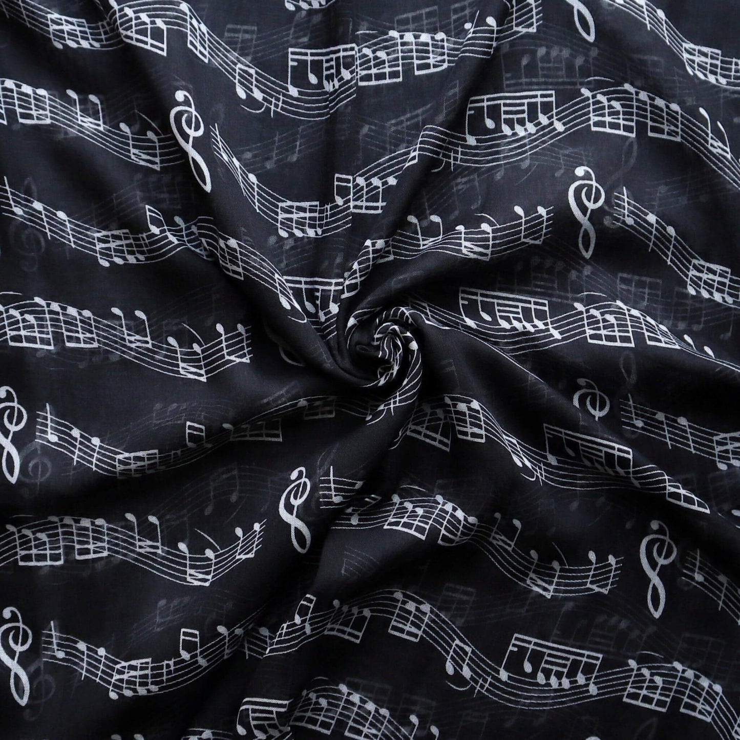Lightweight black scarf fabric with a repeating pattern of white musical notes, clefs, and staff lines. Soft, flowing texture.
