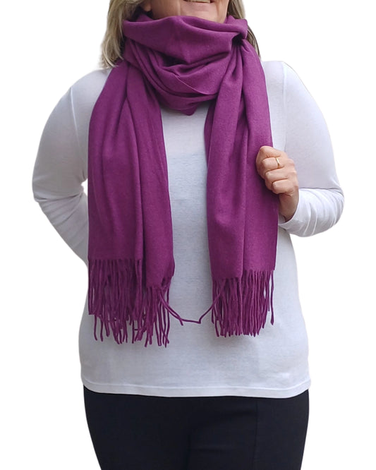 Purple cashmere blend scarf wrapped for winter styling, soft plain medium weight fabric with tassels, bold and elegant