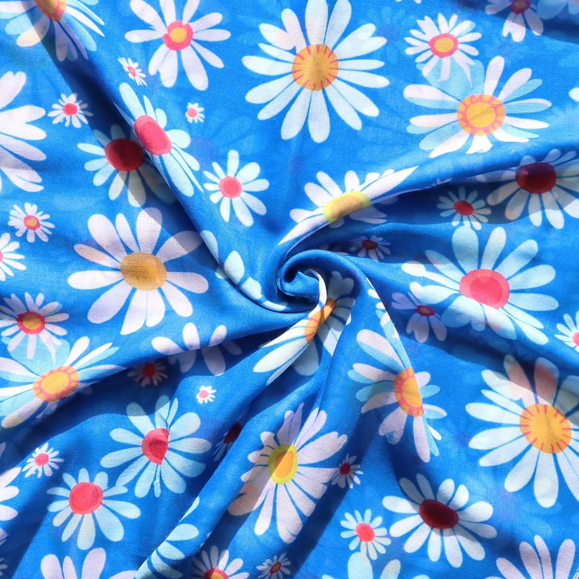 Bright blue scarf fabric with a cheerful daisy design in white, yellow, and pink. Lightweight and stylish textile.