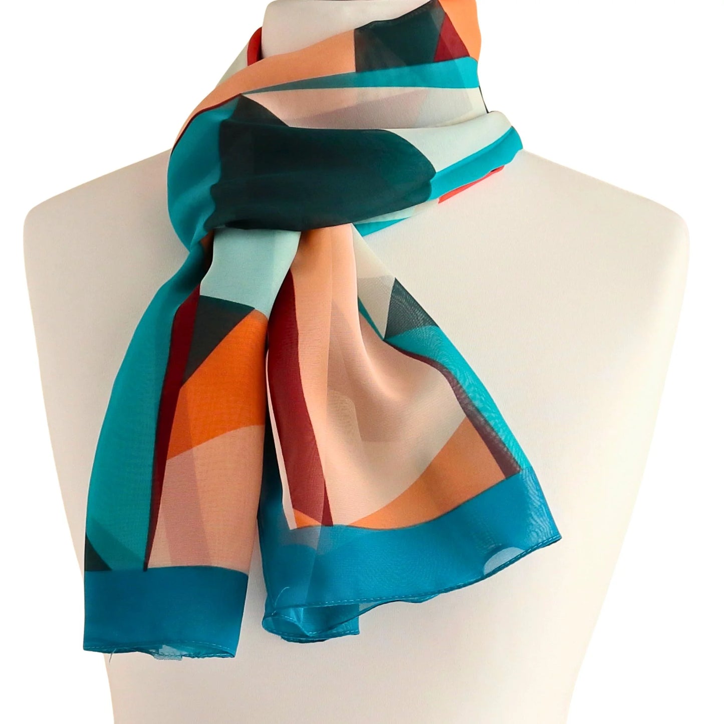 Light chiffon-style scarf with teal geometric print, shown tied at the neck