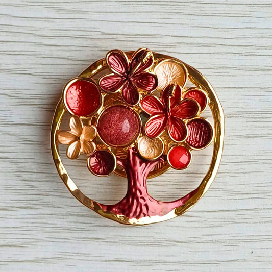Blossom tree magnetic brooch in red decorative painted finish on a wooden surface.