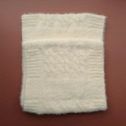 Folded cream Aran-style knitted snood scarf showing its soft fluffy texture