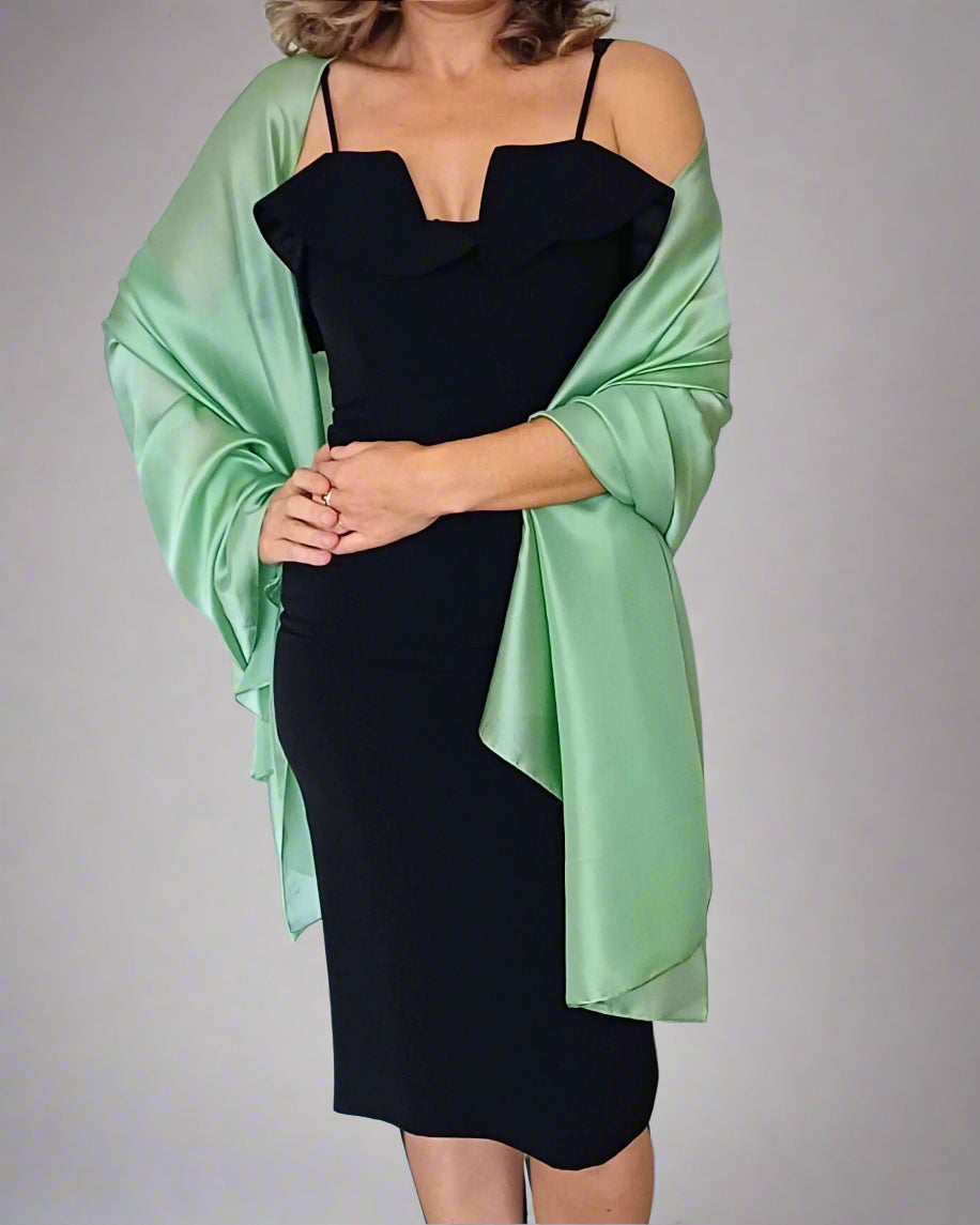 Aurora's Array Elegant Satin Shawl: A woman wearing a fitted black dress has a light green satin shawl draped over her shoulders.