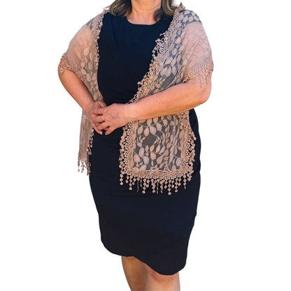 Aurora's Array: Woman models an elegant beige lace scarf with a delicate leaf pattern and fringed edges.