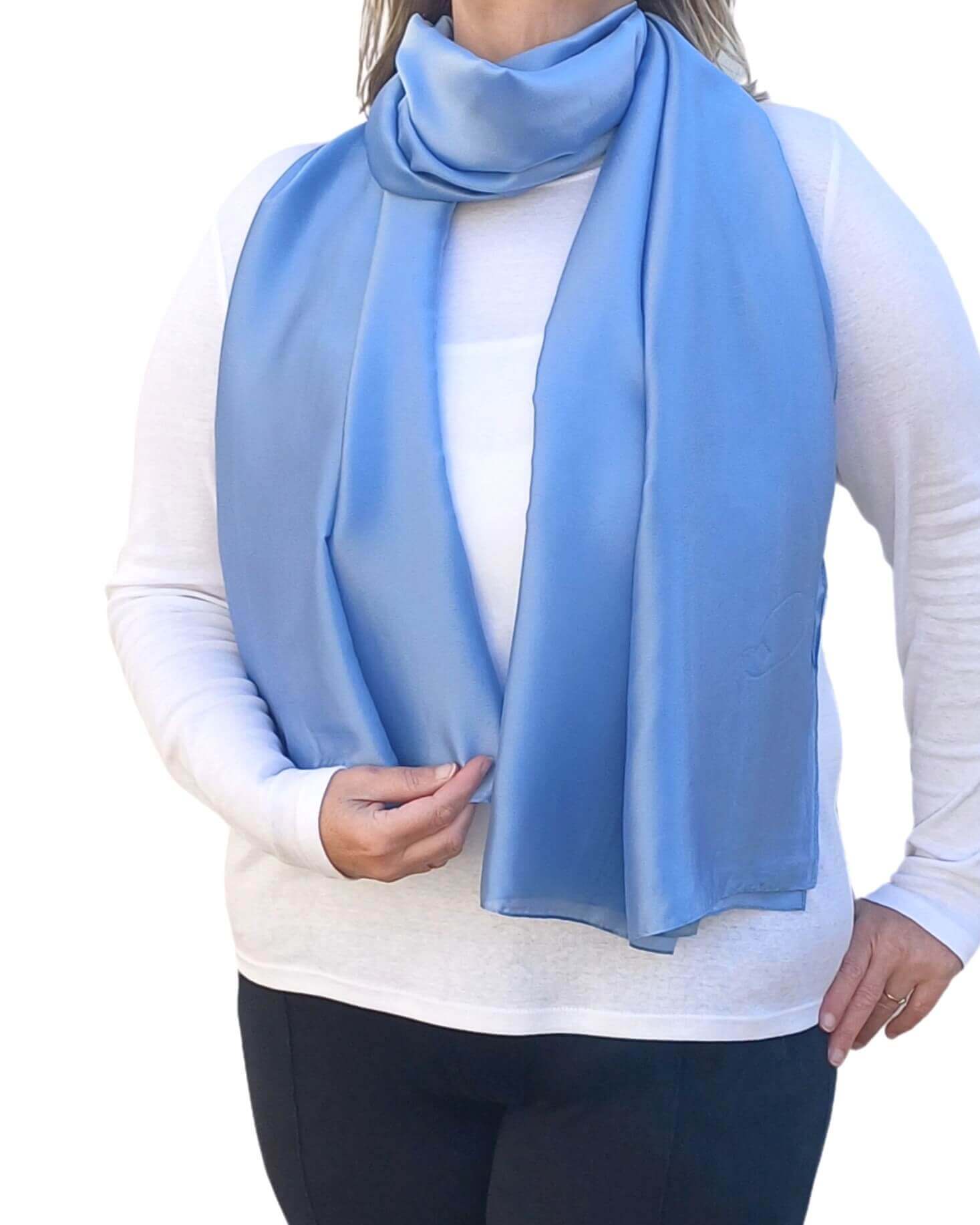 Aurora's Array Elegant Satin Shawl: Woman models a soft, periwinkle blue silky scarf wrapped around her neck over a white top.