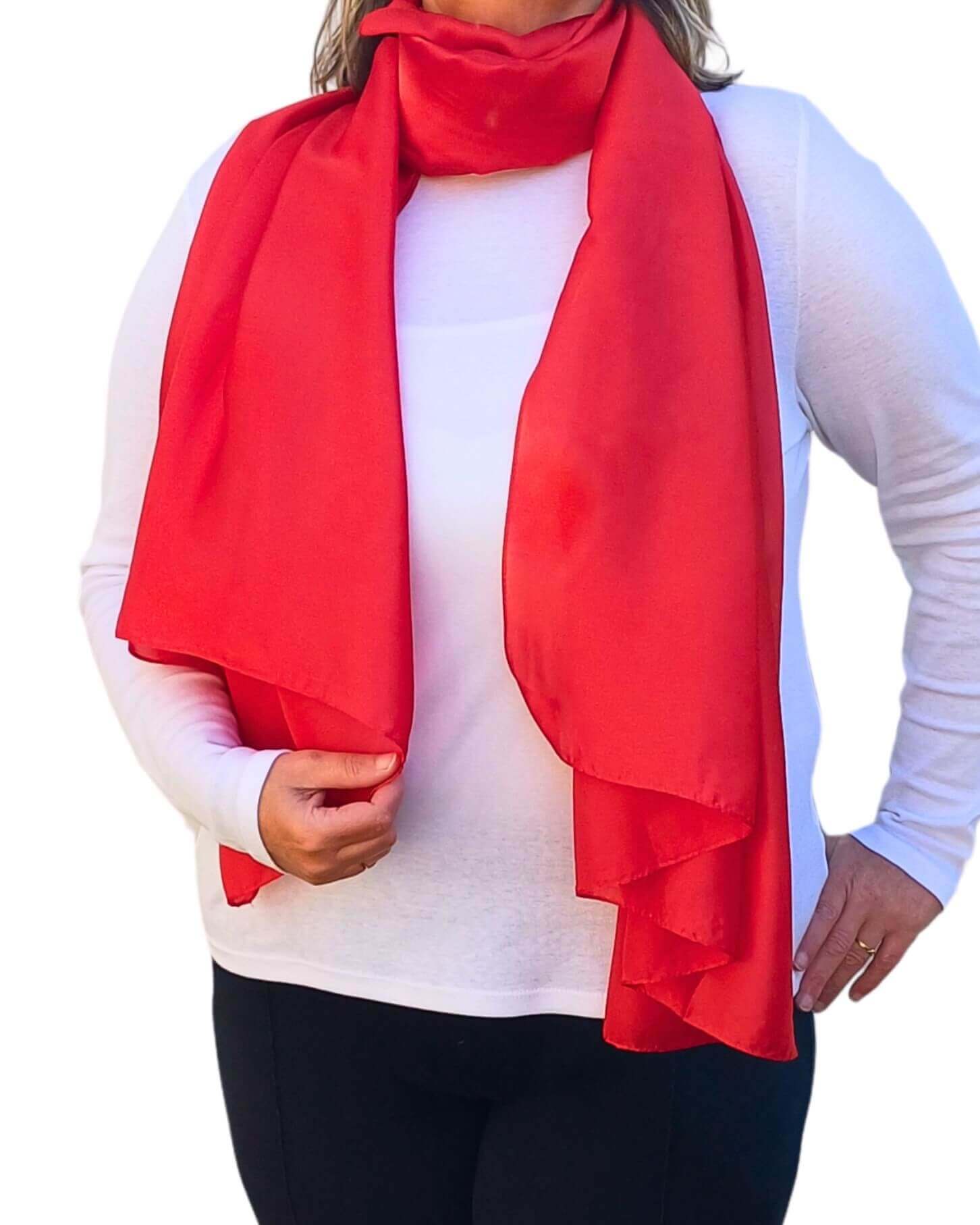 Aurora's Array Elegant Satin Shawl: Woman models a soft, vibrant red silky scarf wrapped around her neck over a white top.