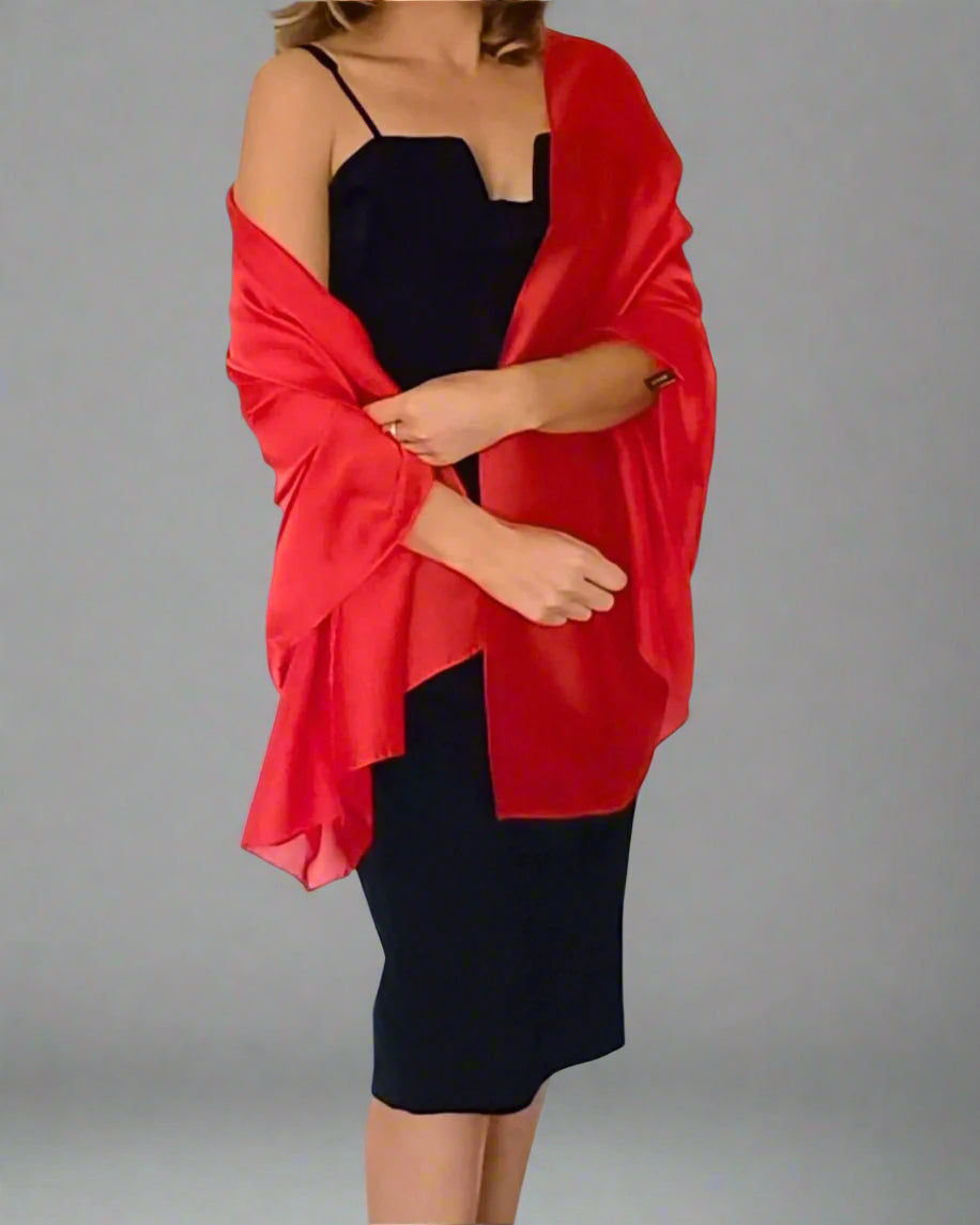 Aurora's Array Elegant Satin Shawl: A woman wearing a fitted black dress has a bright red satin shawl draped over her shoulders.