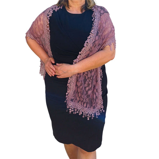 Aurora's Array: Woman models an elegant dusty pink lace scarf with a delicate leaf pattern and fringed edges.