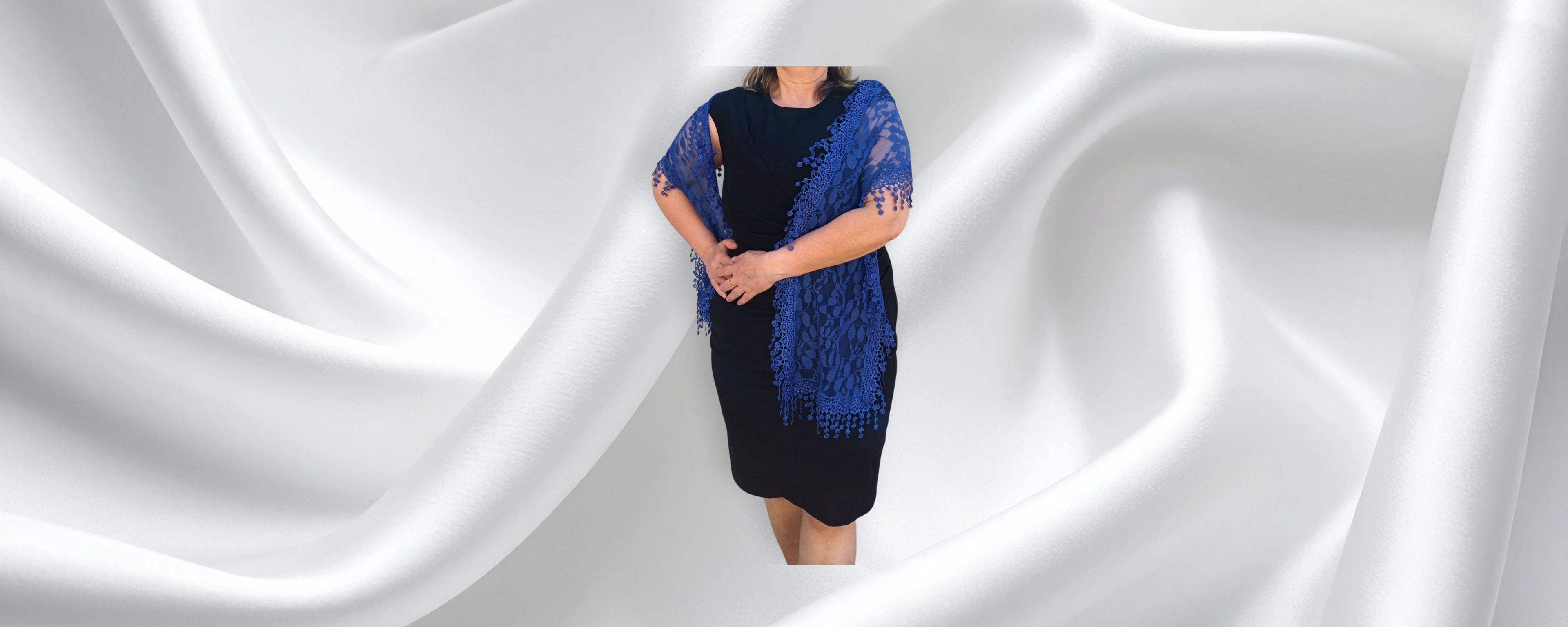 Woman wearing navy lace shawl over black dress for wedding or special occasion