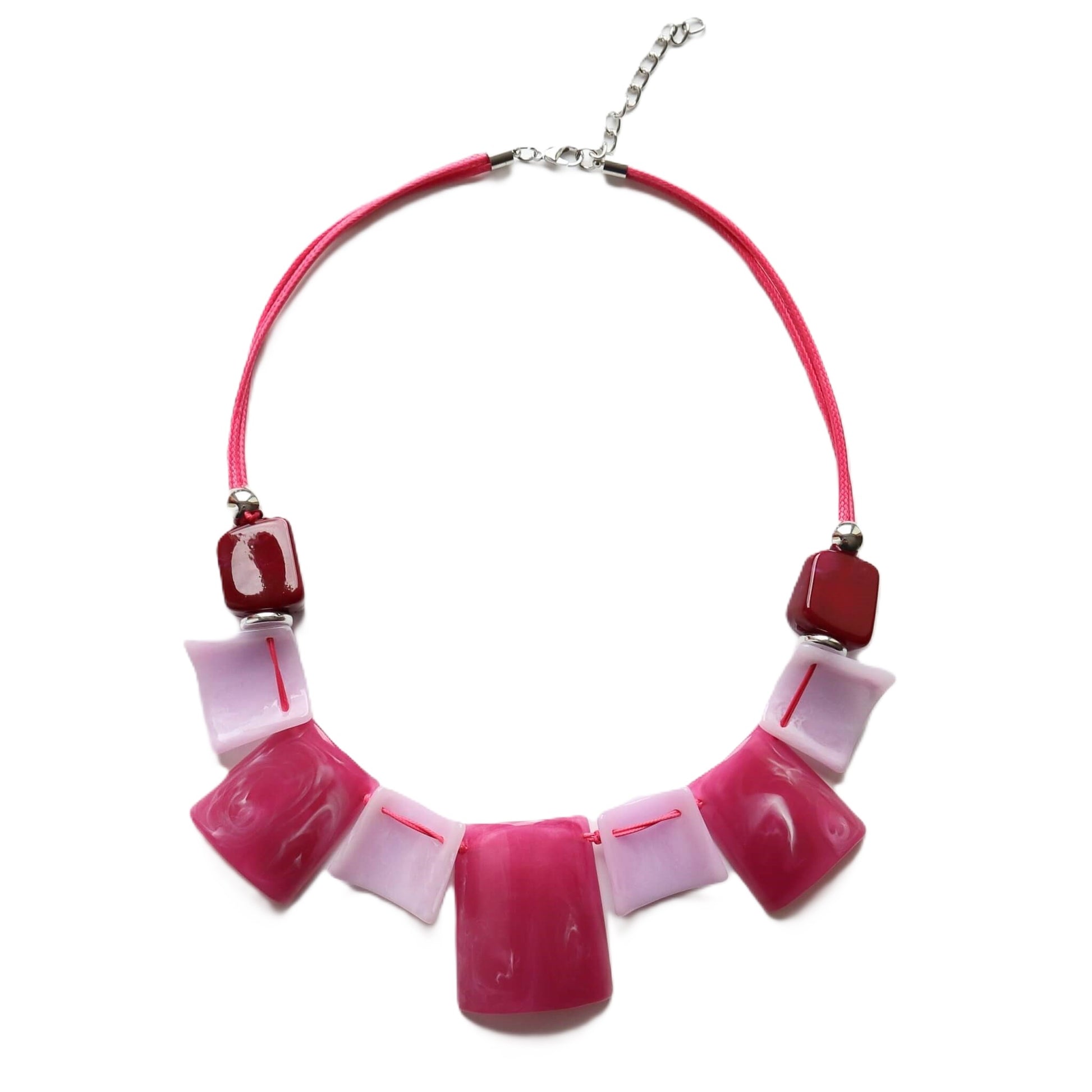 Eye-catching statement necklace with glossy pink, light pink marble, and deep red square and rectangular beads. On a bright pink cord with silver fixings.