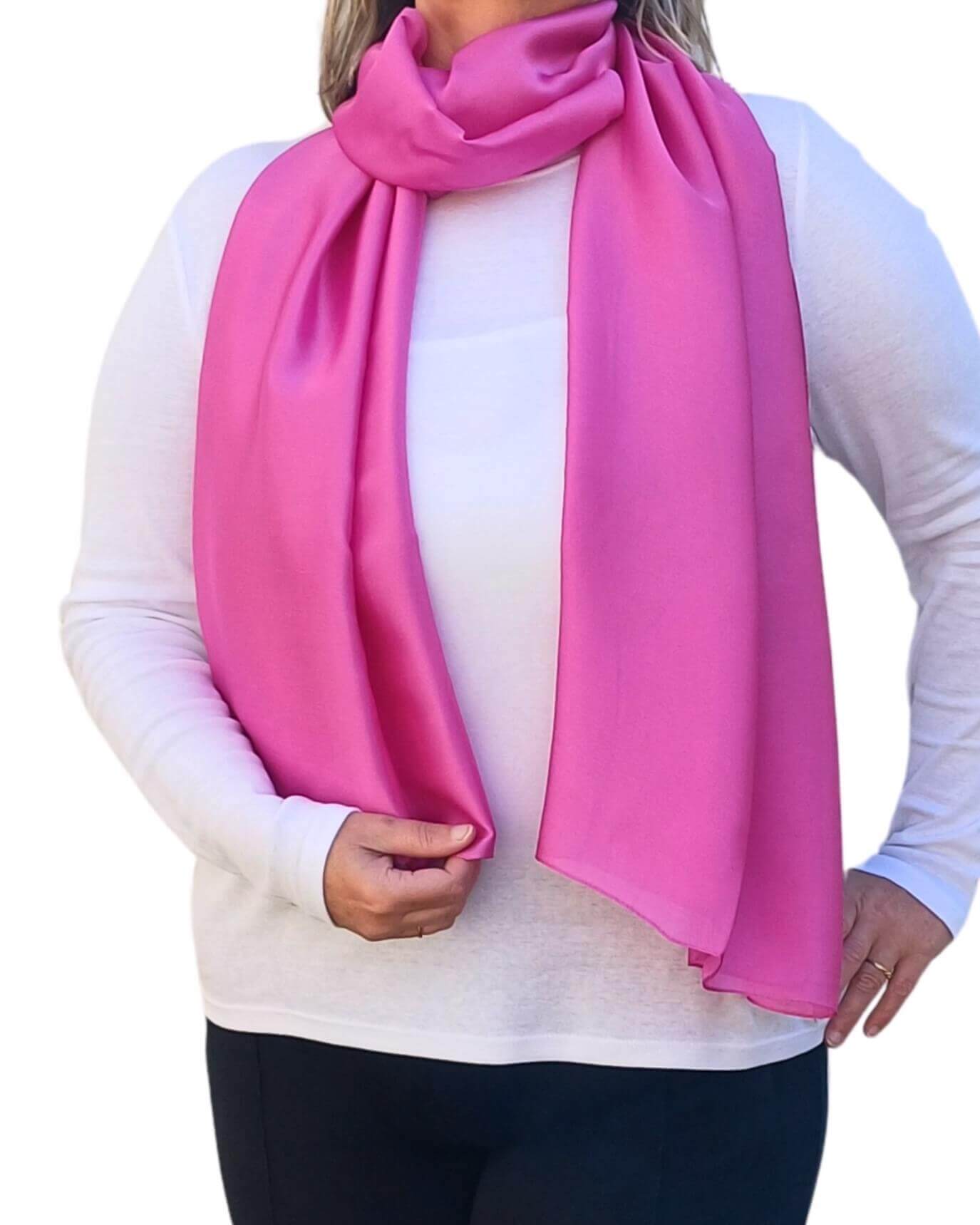 Aurora's Array Elegant Satin Shawl: Woman models a soft, bright pink silky scarf wrapped around her neck over a white top.