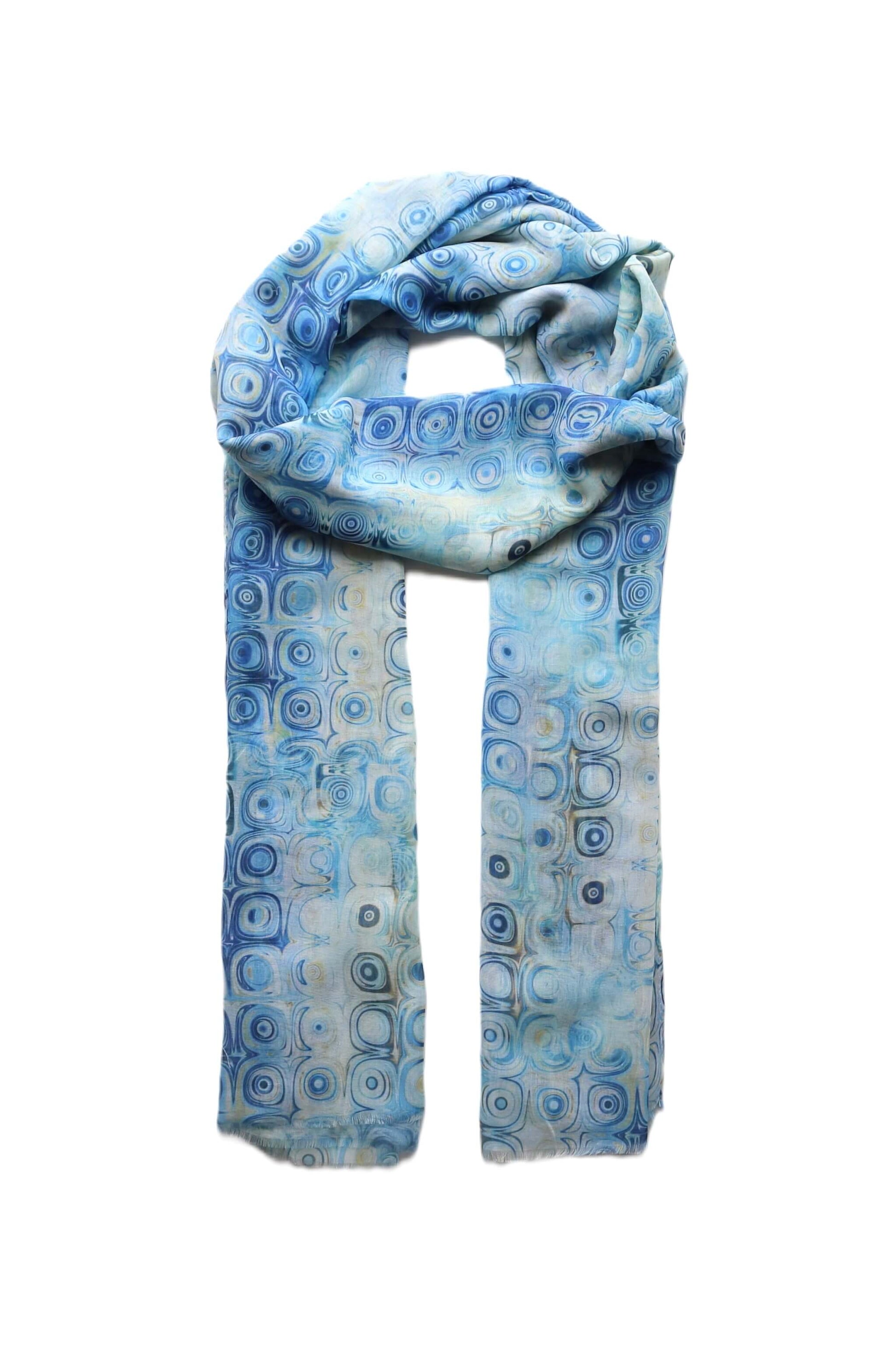 Light blue scarf with a retro geometric circle design in varying blue and white tones. Lightweight and stylish summer accessory.