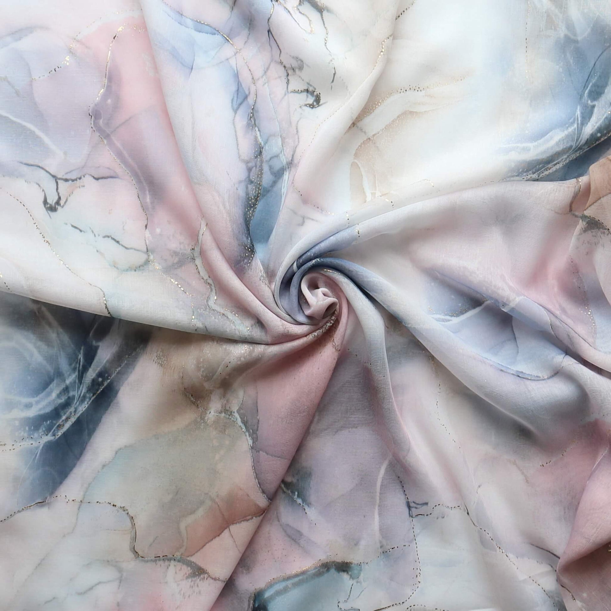 Lightweight scarf fabric with a soft marble effect in blue, pink, and cream, featuring subtle gold shimmer threads. Delicate summer textile.