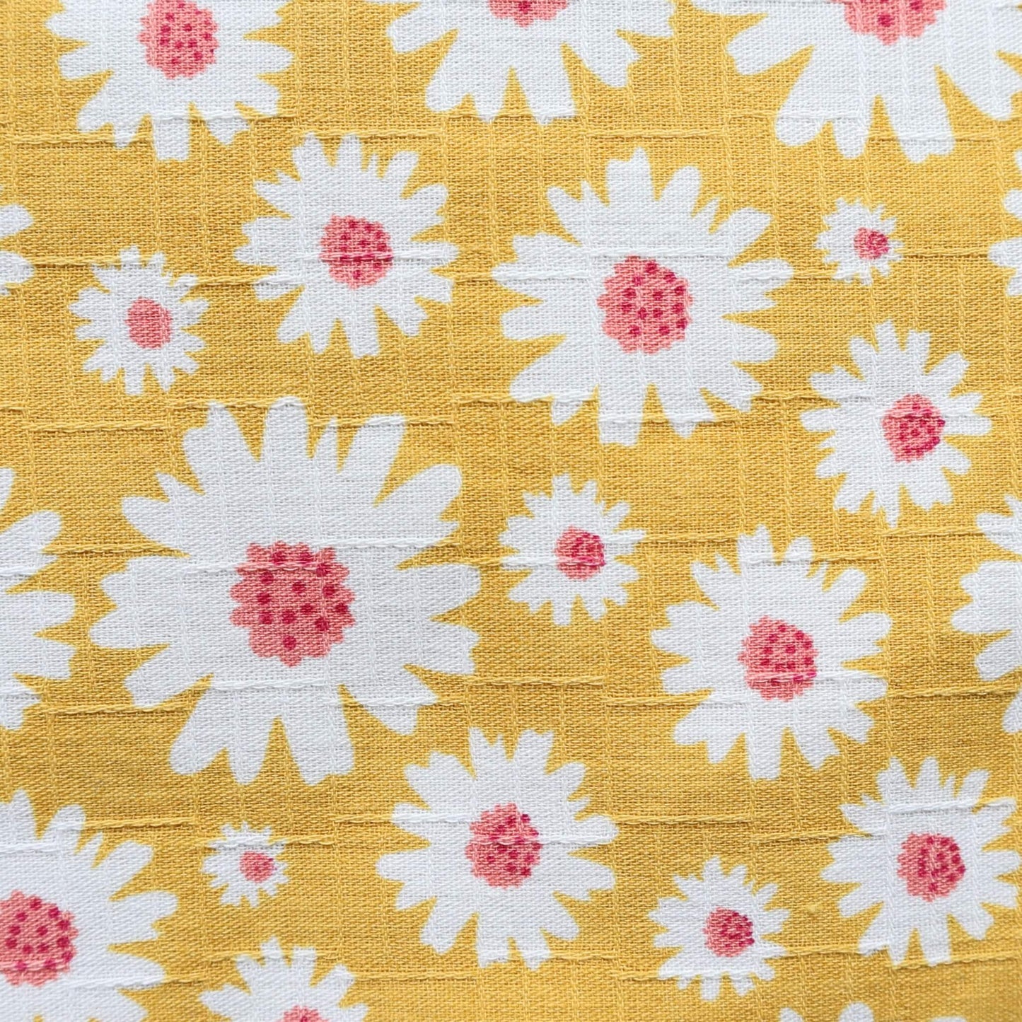 Detailed view of a yellow textile featuring a repeating white daisy design with textured pink centers.